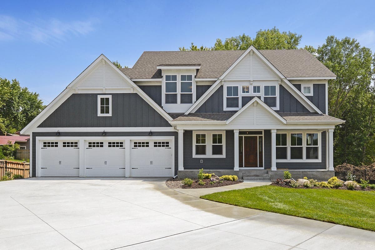 House plan exterior featuring a two-story Craftsman style home with three-car garage, multiple gables, and a front porch with columns.