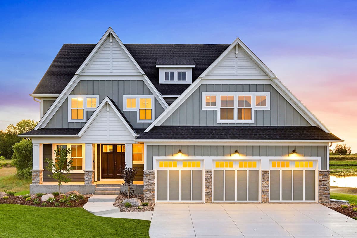 House plan exterior featuring a two-story Craftsman home with multiple gables, a covered porch, and a three-car garage.