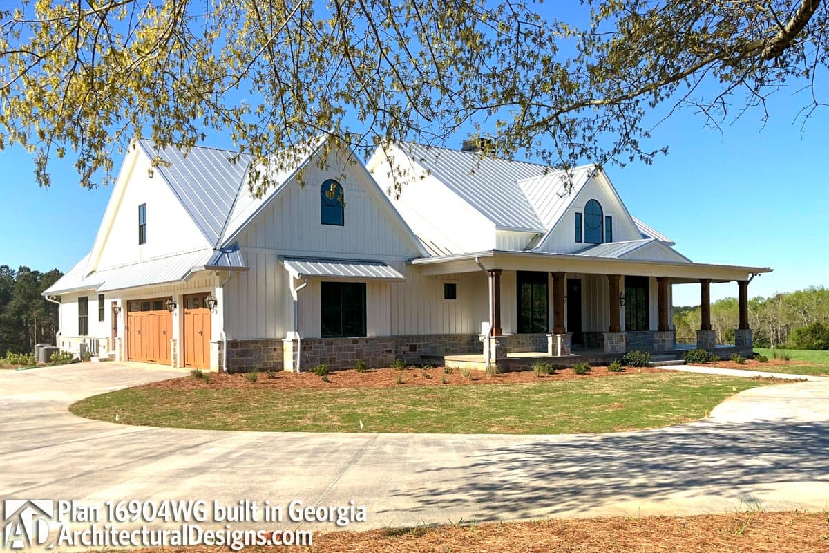Modern Farmhouse house plan exterior with metal roof, gables, wide front porch with stone bases, and side-entry garage.