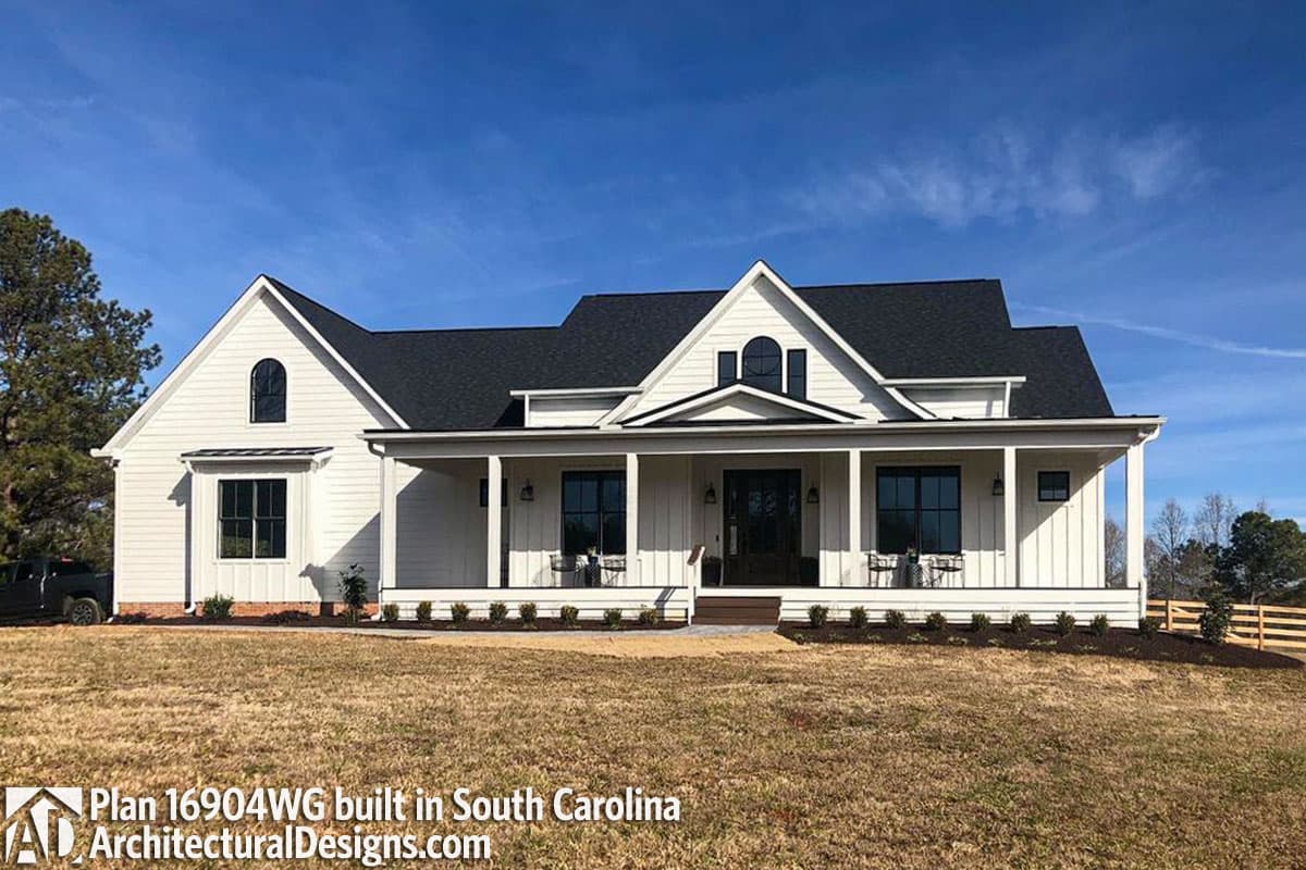 Modern Farmhouse house plan exterior with wraparound porch, gables, and arched dormer window.