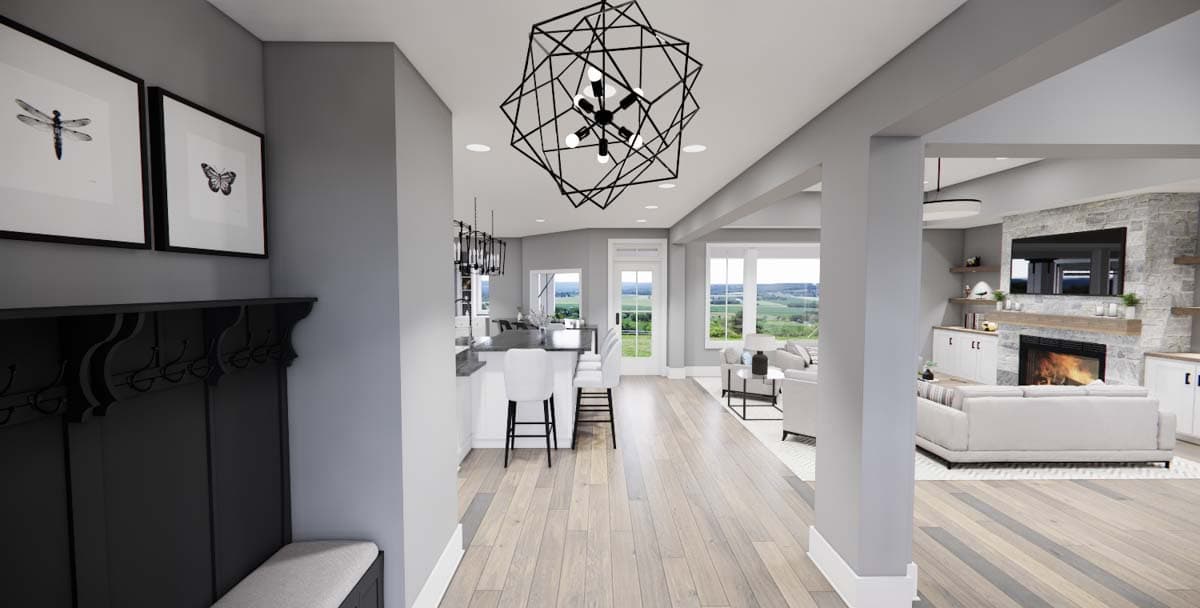 Open concept living area with kitchen island, fireplace, and large windows.