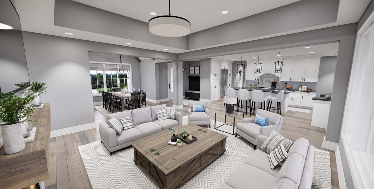 Open concept living area with two sofas, a coffee table, dining area, and kitchen with island and bar stools.
