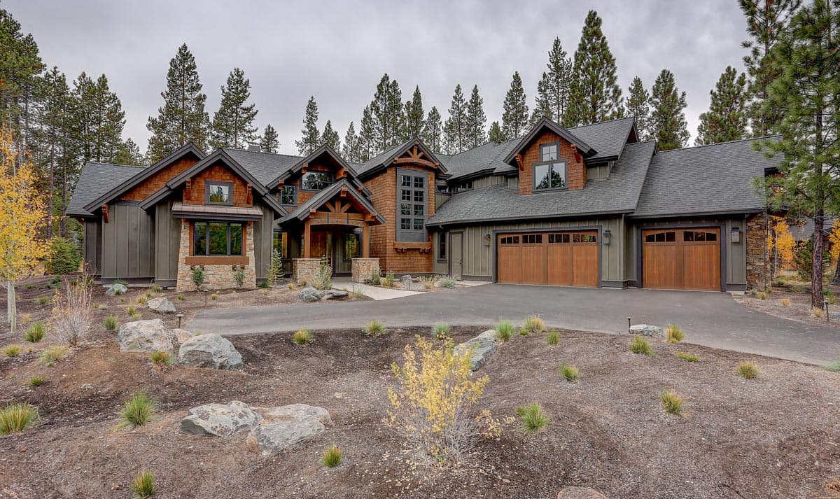 House plan exterior: Modern mountain home with multi-level gables, wood and stone accents, and a three-car garage.
