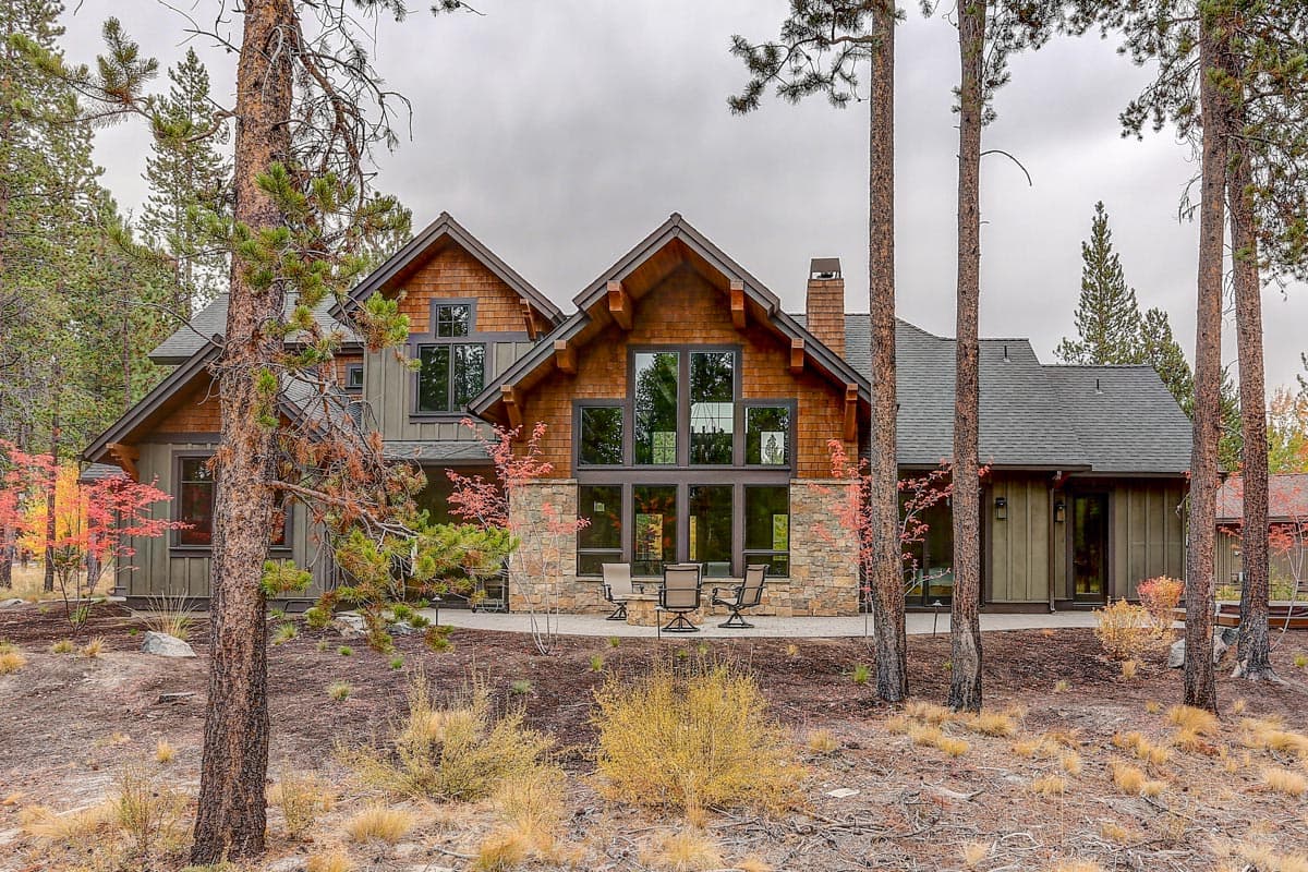 House plan exterior: two-story Modern Farmhouse with stone accents, large windows, gables, and timber framing.