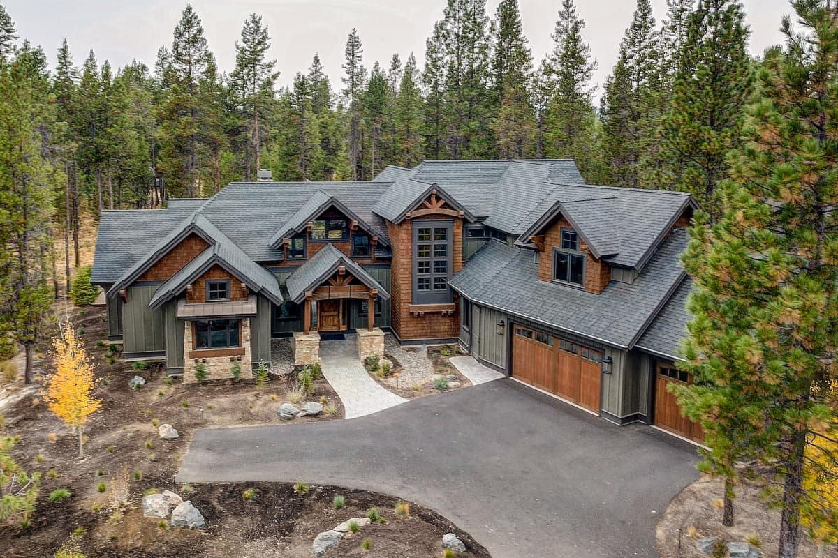 House plan exterior. Craftsman style with multiple gables, wood-clad dormers, and a prominent front porch. Two-story with attached garage.