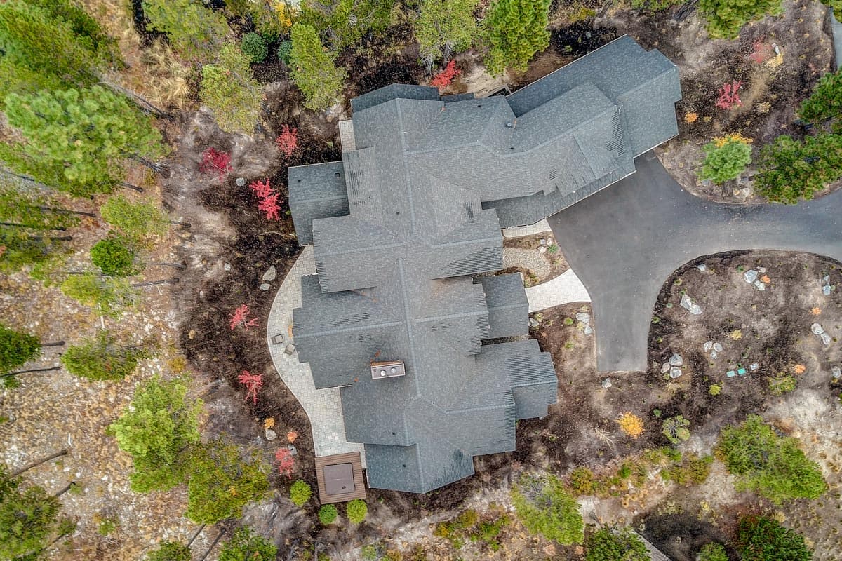 House plan exterior with multi-gabled roofline, complex roof planes, and asphalt driveway.