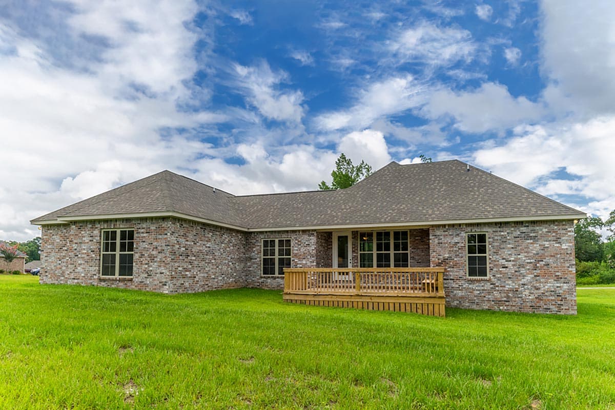 House plan exterior of a one-story brick home with multiple gables and a wooden deck.