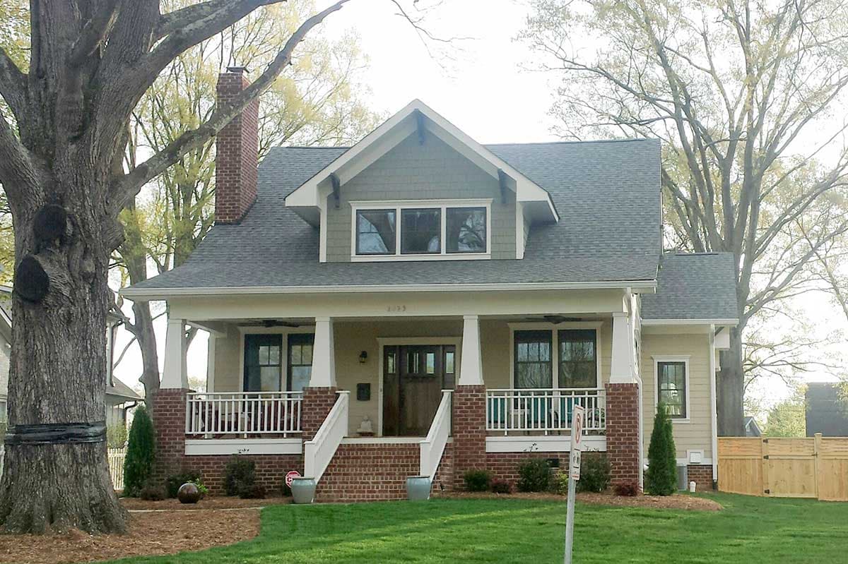 Craftsman-style house plan exterior with a covered porch, brick base, gable dormer, and brick chimney.