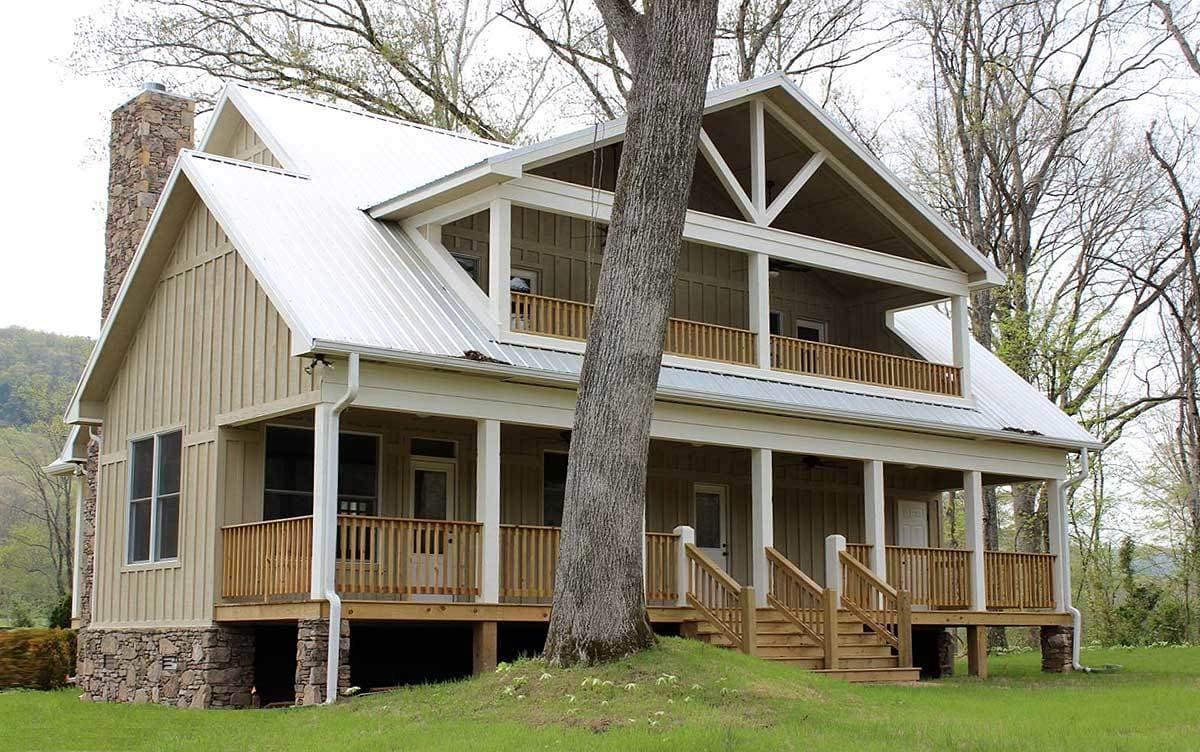 House plan exterior: Two-story Modern Farmhouse with metal roof, stone foundation, and wraparound porch with gables.