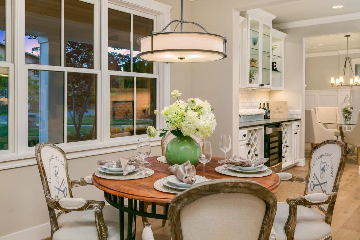 Dining area with round table, chairs, wine cabinet, and display hutch.
