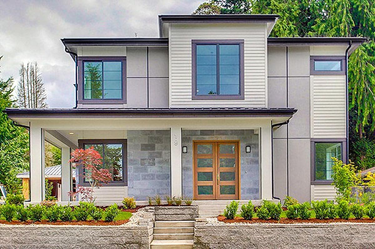 Modern house plan exterior. Two-story home with a covered porch, clerestory windows, and a flat roofline. Features wood-paneled entry doors.