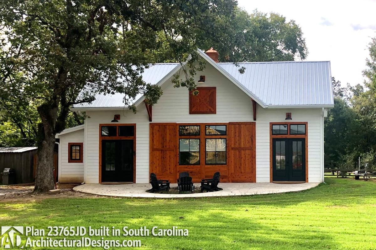 Modern Farmhouse house plan exterior with metal roof, large wooden barn doors, and double entry doors.