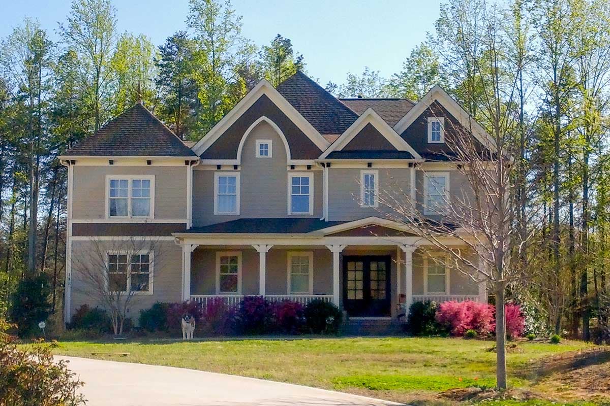 Two-story house plan exterior with Craftsman influences. Features include multiple gables, a covered porch, and a dark shingled roof.