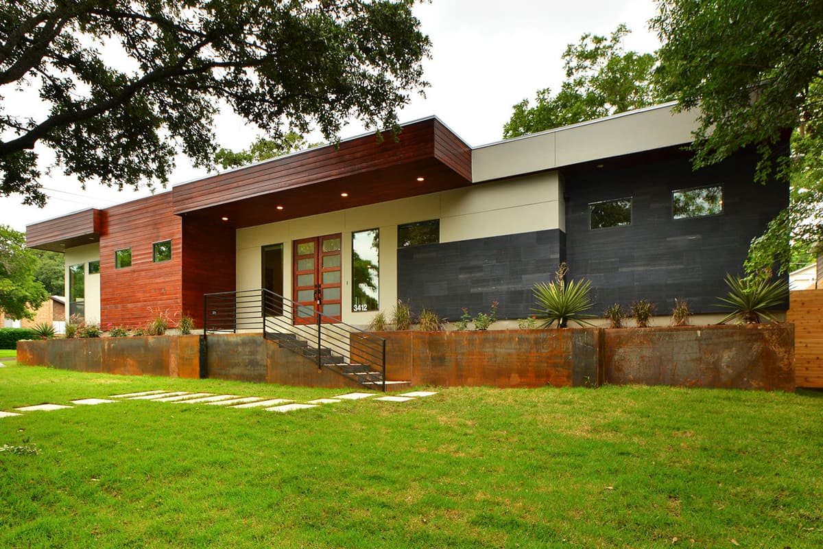 Modern house plan exterior with wood siding, dark stone facade, flat roof, and raised planter beds.