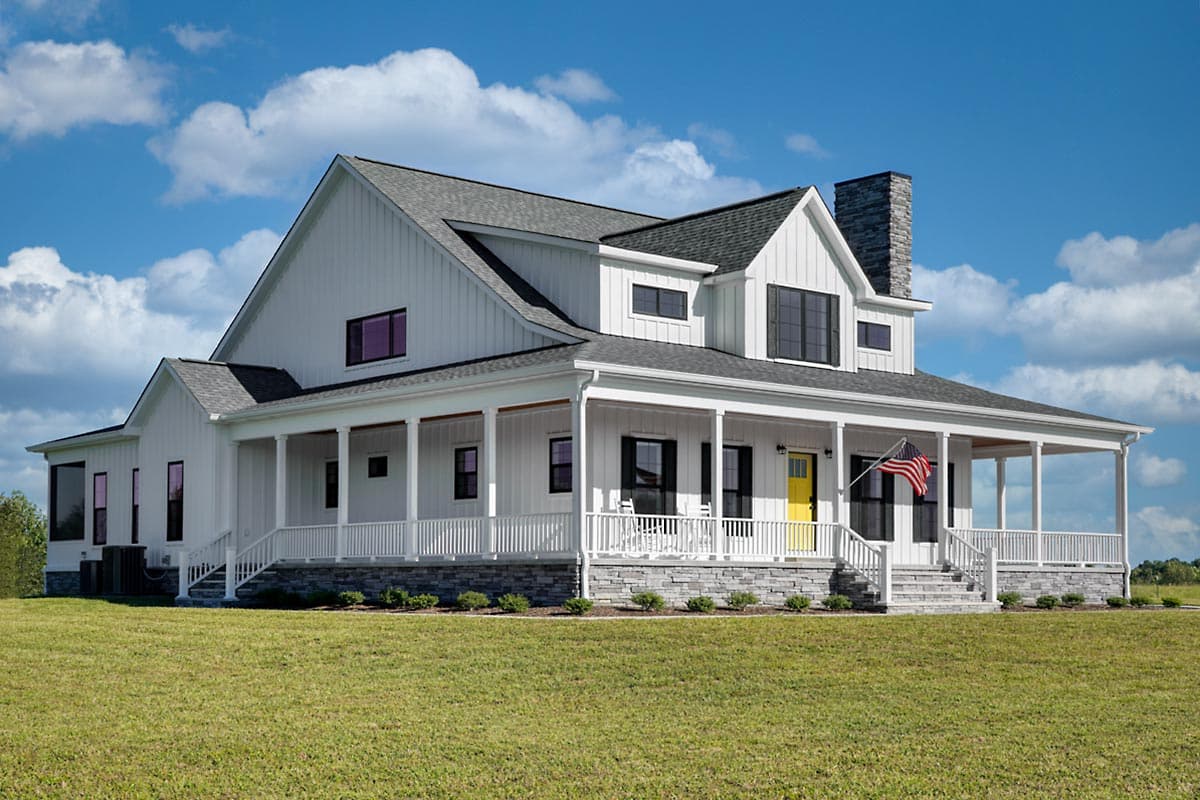 Modern Farmhouse house plan exterior with wraparound porch, gables, vertical siding, and stone foundation.