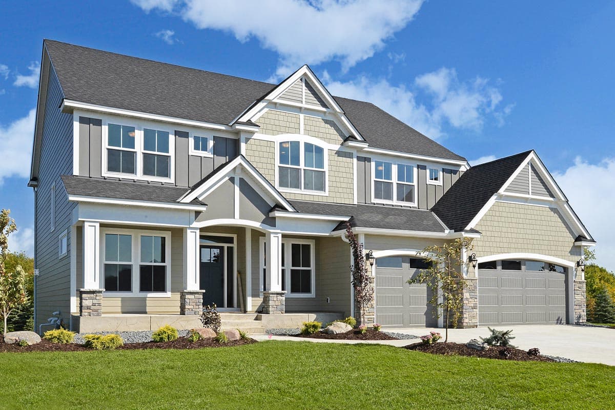 Two-story house plan exterior with gabled roof, covered porch, and attached garage. Features include mixed siding and stone accents.