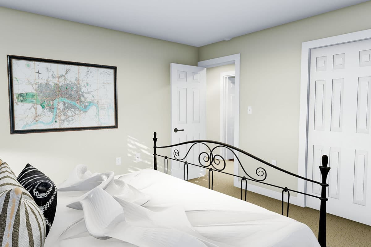 Bedroom with map art, black metal bed frame, closet, and doorway to hallway.