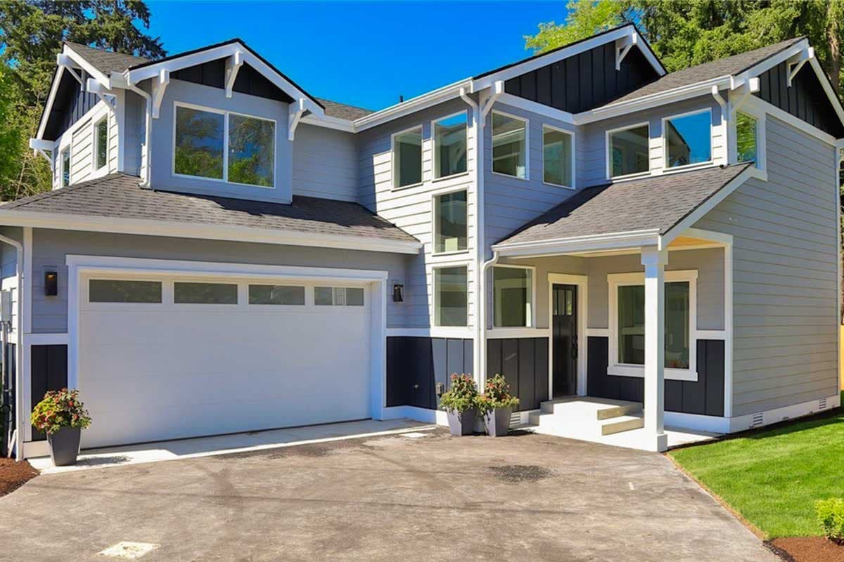House plan exterior: Two-story modern home with a white garage door, prominent gables, and a covered entry porch.