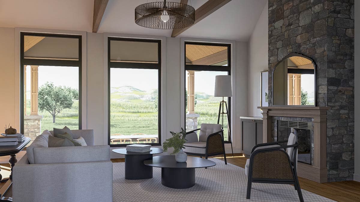 Interior rendering of a great room with stone fireplace, vaulted ceiling with exposed beams, and large windows overlooking a landscape.