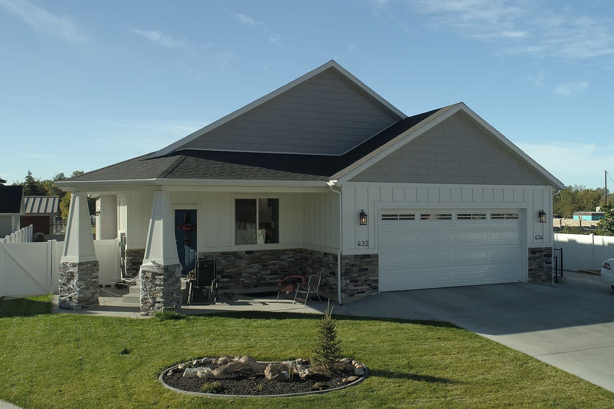 Modern Farmhouse house plan exterior with a covered front porch, stone accents, gable roof, and attached garage.