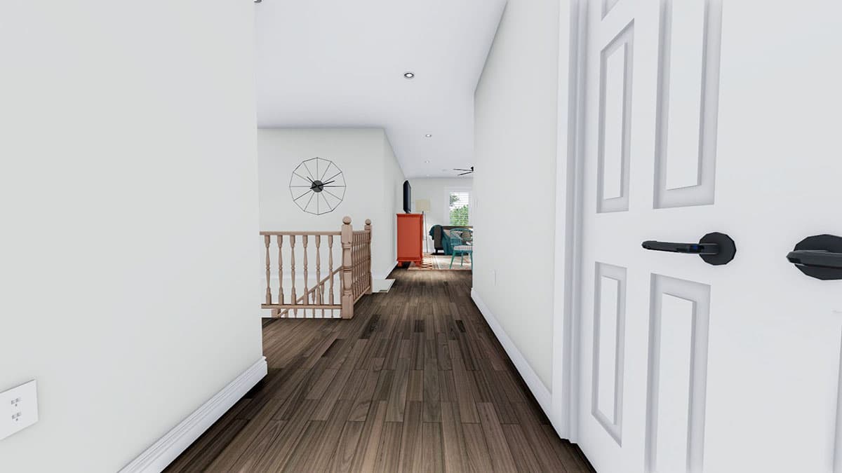 Interior view of a hallway with wood flooring, staircase, and open doorway to a living area.