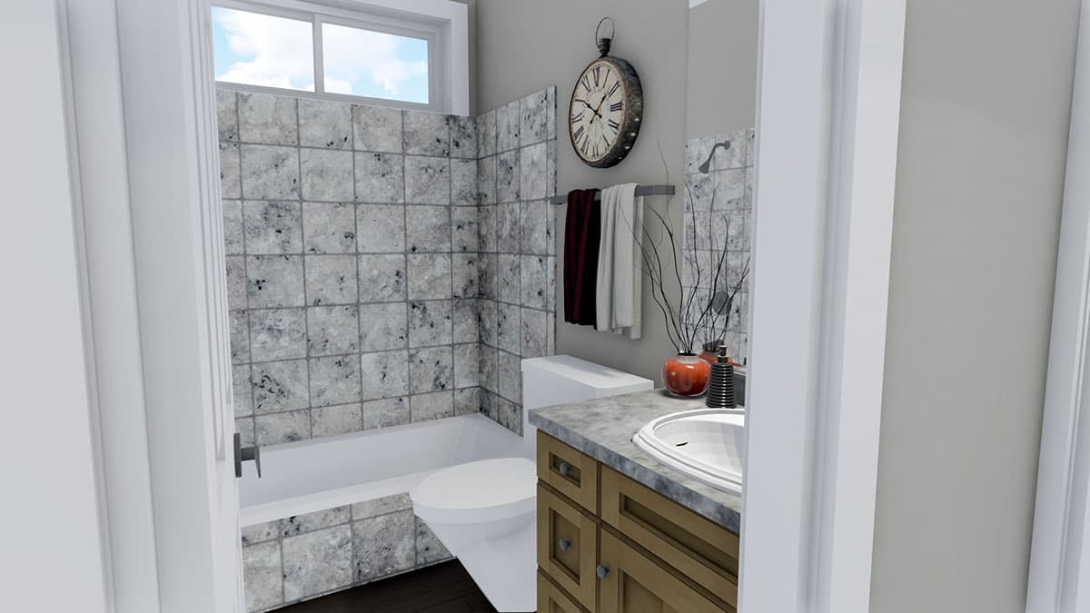 Bathroom interior with tiled tub-shower, toilet, vanity with dual-handle sink, and window.
