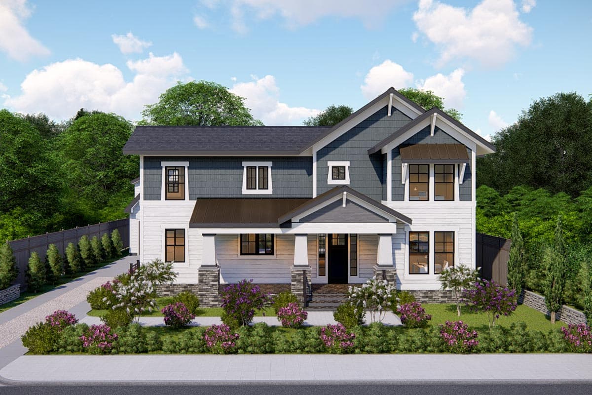 A two-story house with white siding, dark gray roofing and accents, and a porch lined with landscaping and pink flowering bushes under a blue sky.
