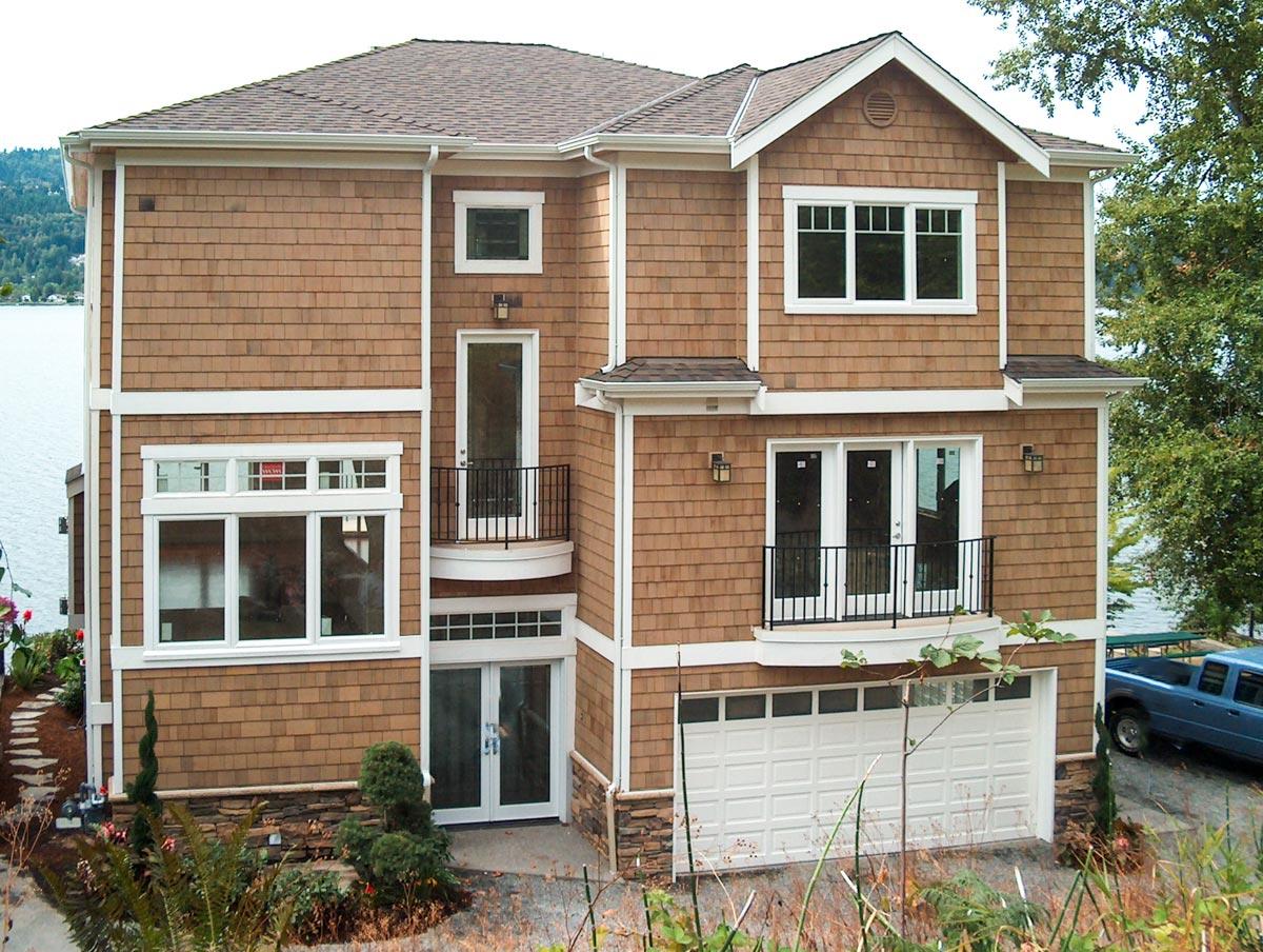 House plan exterior with cedar shake siding. Two-story design with a gable roof, multiple balconies, and a front-facing garage.