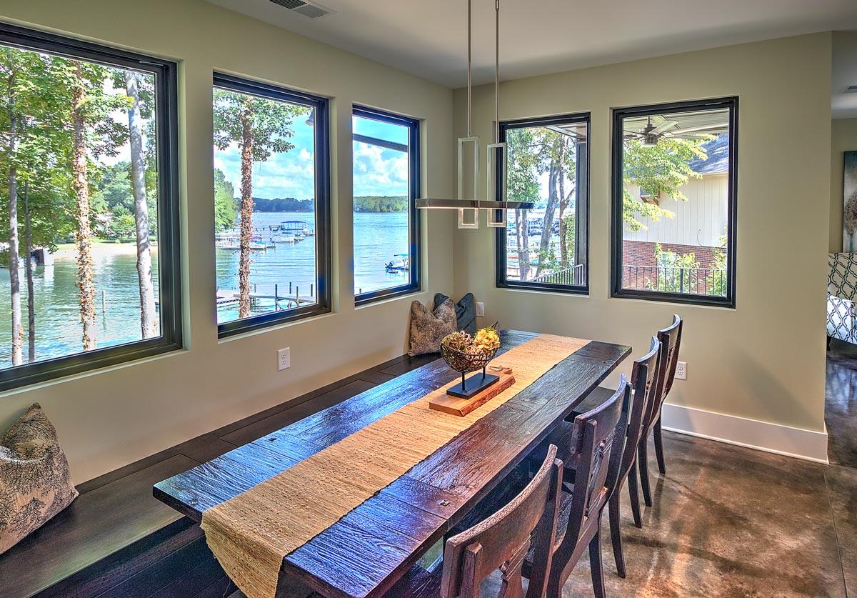 Dining room with lake view, dark wood table, bench seating, and modern pendant light.