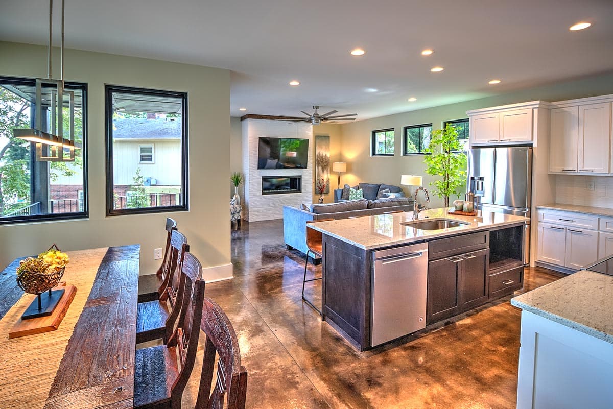 Open concept living area with kitchen island, dining table, fireplace, and seating area.