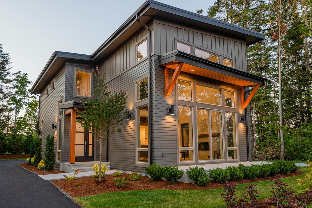 Modern two-story house plan exterior with board and batten siding, large windows, wood accents, and a covered entryway.