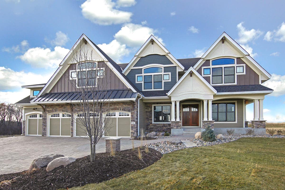 House plan exterior. Craftsman style, two-story home with multiple gables, covered porch with columns, and three-car garage.