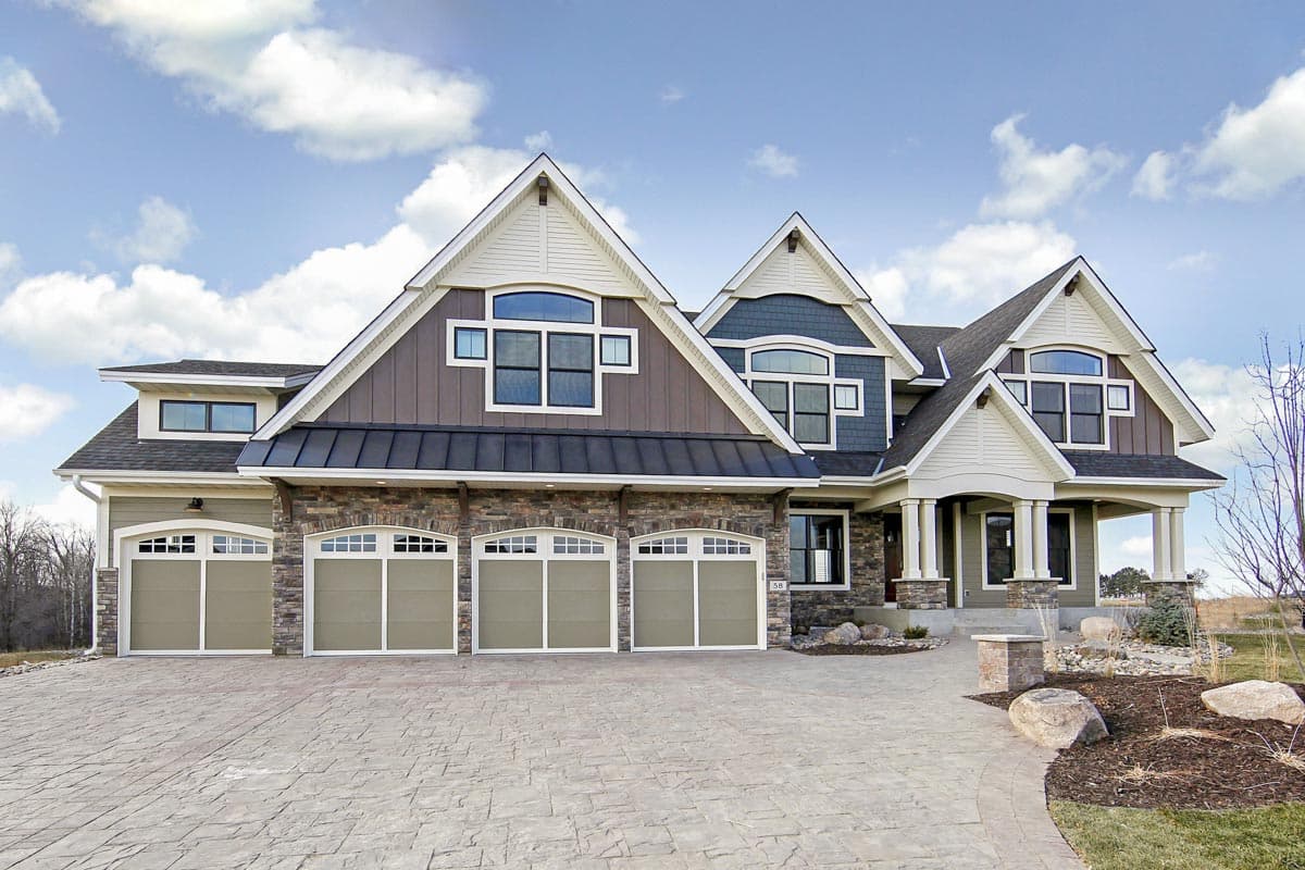 House plan exterior: two-story residence with five garage bays, stone facade, multiple gables, and covered front entry.
