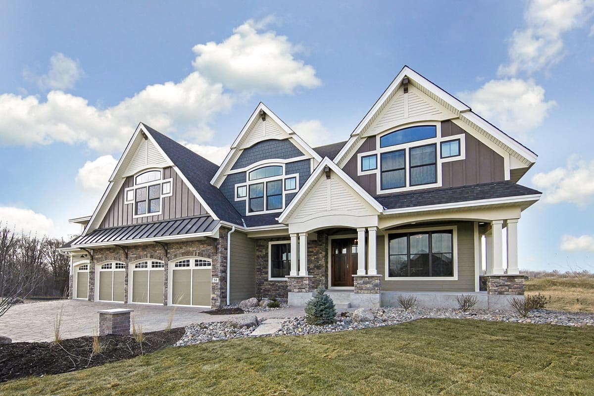 House plan exterior with stone and siding, five garage bays, gables with dormers, and a covered entry with columns.
