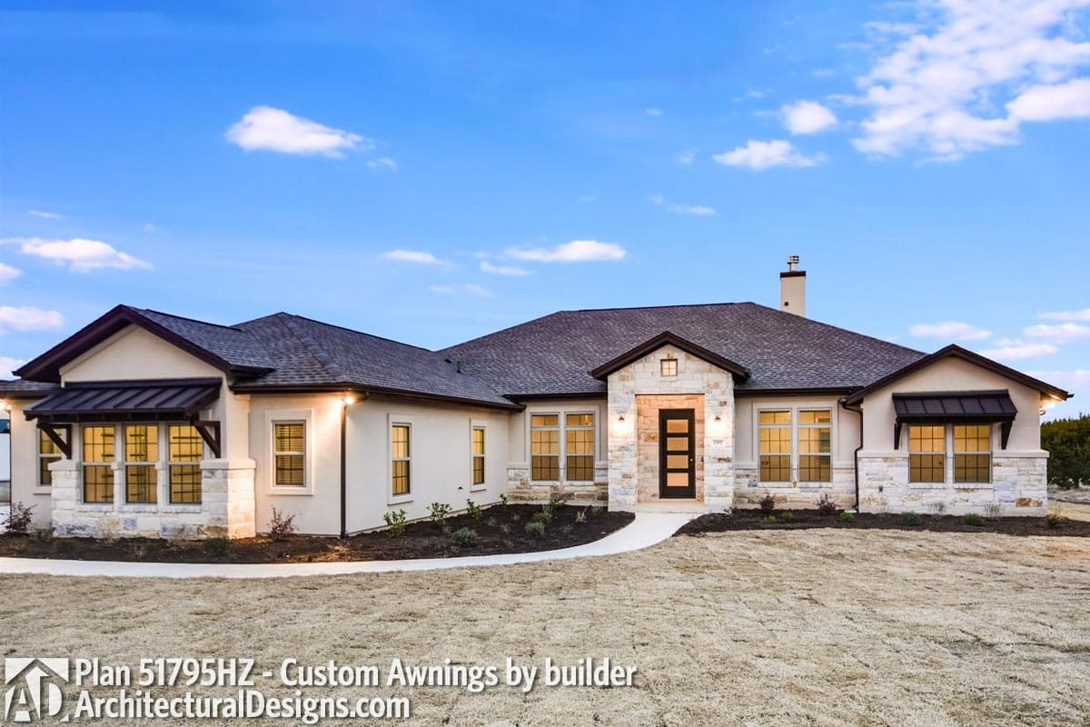 House plan exterior: single-story Modern Farmhouse with stone accents, dark awnings, multiple gables, and a central entryway.