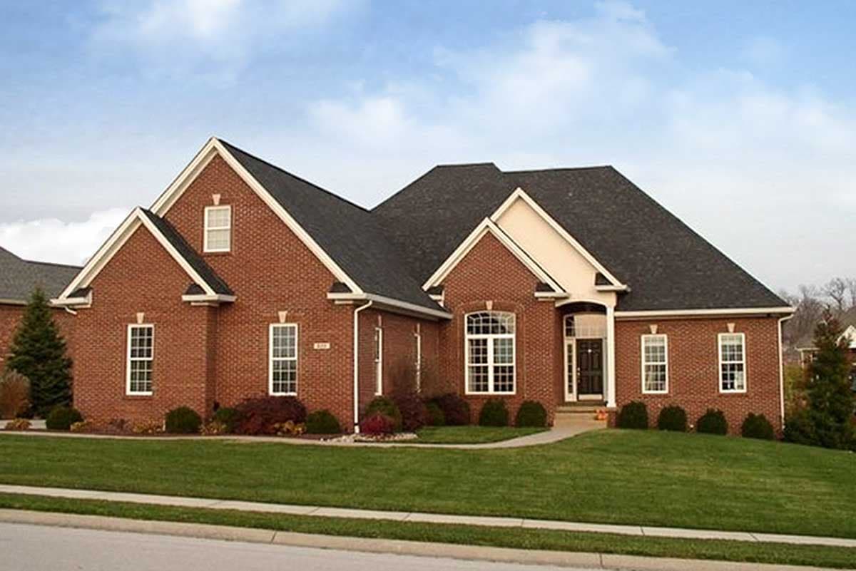 House plan exterior: Brick ranch with multiple gables, a covered entry with arched windows, and a two-car garage.