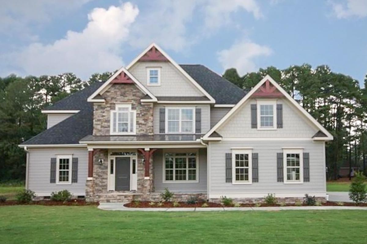 Two-story house plan exterior with stone accents, covered entry porch, multiple gables with decorative trim, and gray shutters.