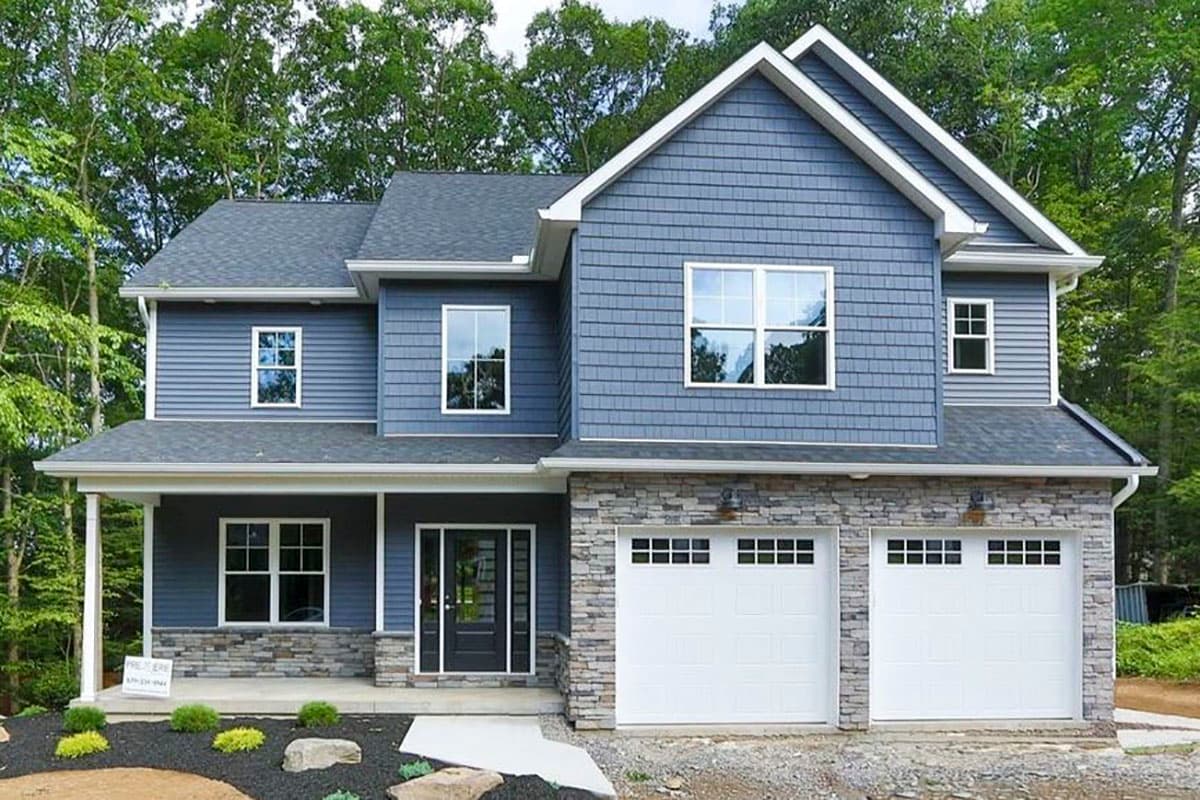 House plan exterior featuring a two-story Craftsman-style home with gabled roof, stone veneer, and a front-facing, two-car garage.