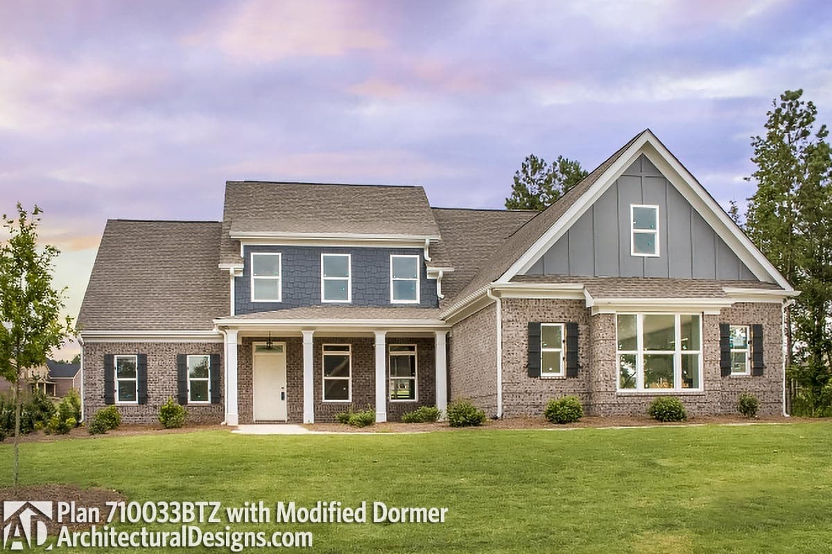 House plan exterior featuring brick facade, covered porch with columns, gabled dormer, and dark shutters.