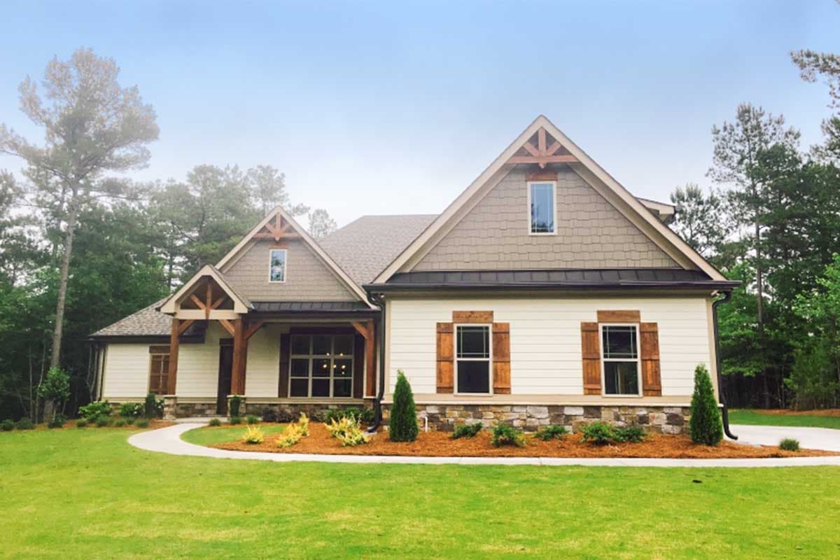 Craftsman style house plan exterior with gabled dormers, stone wainscoting, wood shutters, and exposed beam porch.