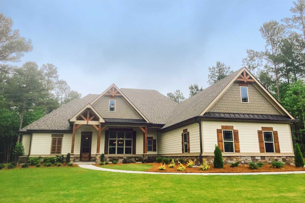 Craftsman style house plan exterior with a prominent gable, exposed wood beams on the covered entry, and stone accents.