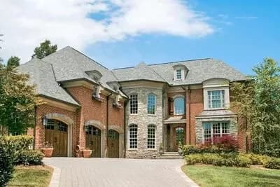 Luxury Home Plan with Stone Turret and 3-Car Courtyard-Style Garage