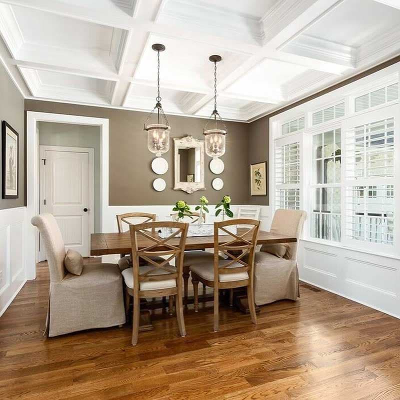 Dining room with coffered ceiling, large windows with shutters, and a wooden dining set.