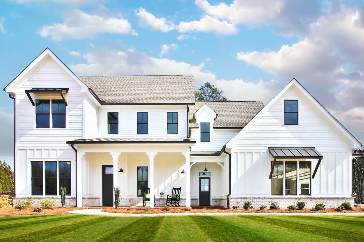 House plan exterior featuring a two-story Modern Farmhouse design with gabled rooflines, covered porch, and black-framed windows.