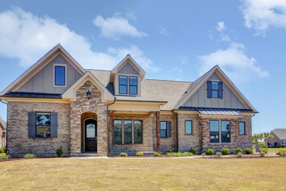 House plan exterior: Two-story Modern Farmhouse with brick facade, stone accents, arched entry, dormers, and multiple gables.