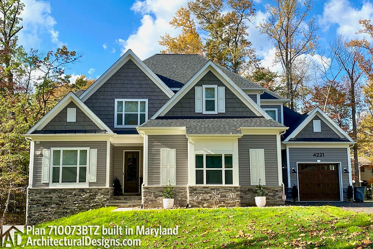 House plan exterior with multiple gables, shingle and siding accents, and a two-car garage with carriage-style door.