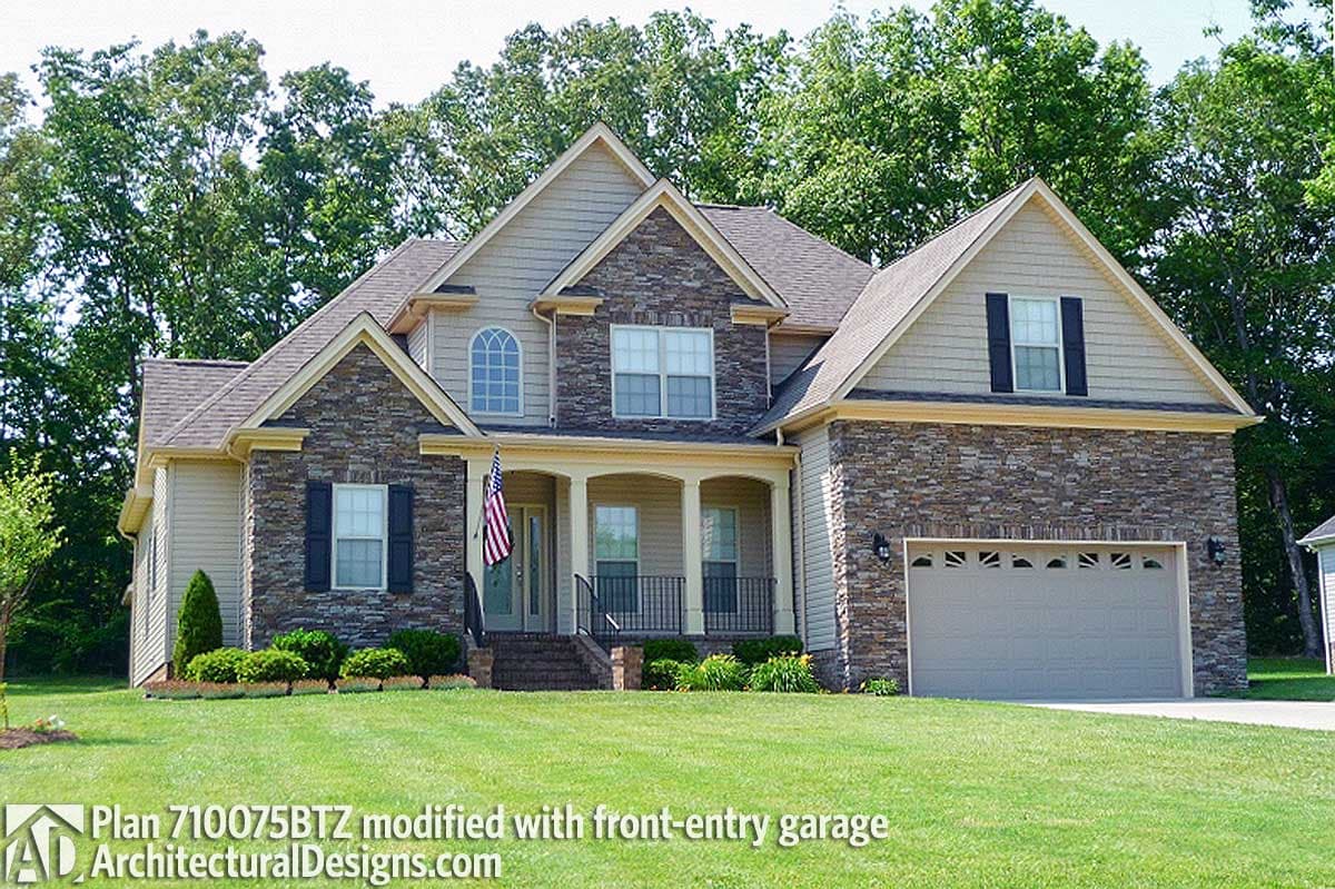 House plan exterior: Two-story home with stone accents, arched window, covered porch, and front-entry garage.