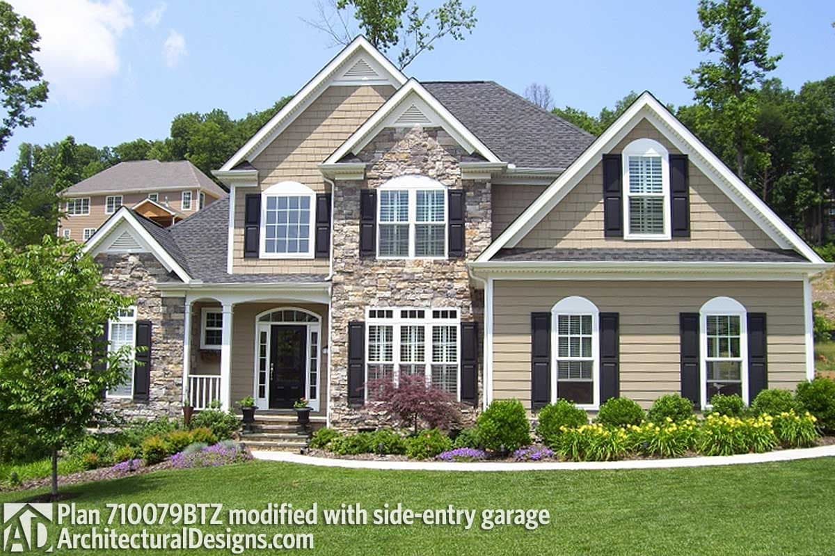 House plan exterior with stone accents, covered entry porch, multiple gables, and arched dormer windows.