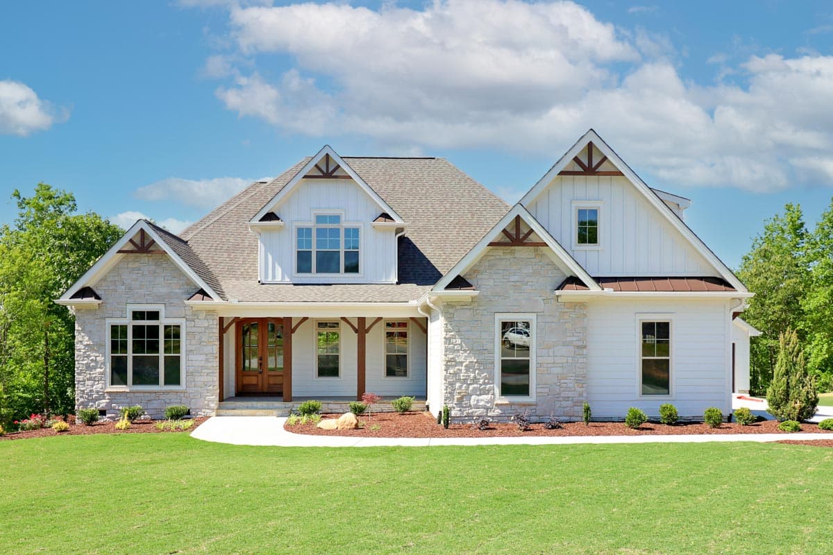 House plan exterior. Two-story Modern Farmhouse with gabled roof, stone accents, and covered porch with exposed beams.