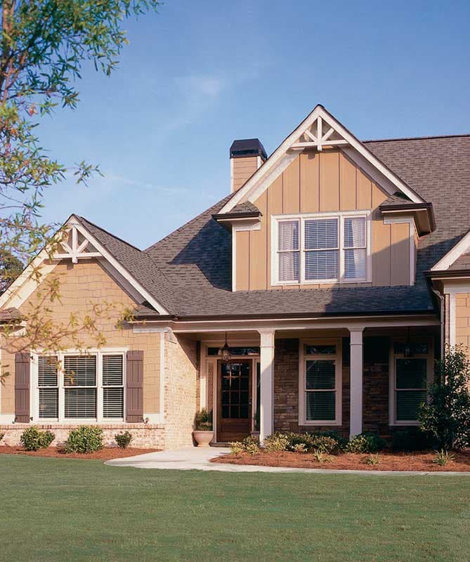 House plan exterior with a covered entry porch supported by columns, stone and shingle siding, and decorative gables.
